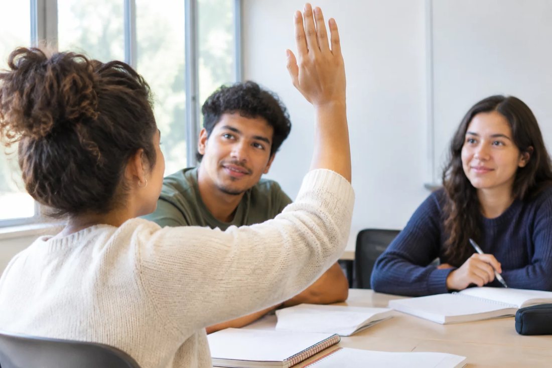 Facilitador em pé apontando para um argumento escrito no quadro durante a sessão